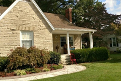 a large brick building with grass in front of a house